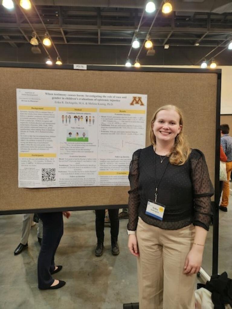 Photo of Erika DeAngelis in front of a poster presentation