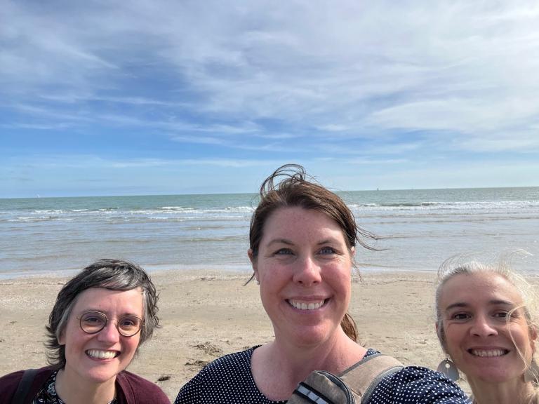 Meghan Allen Eliason in front of the Mediterranean Sea with two staff members from the Montpellier program