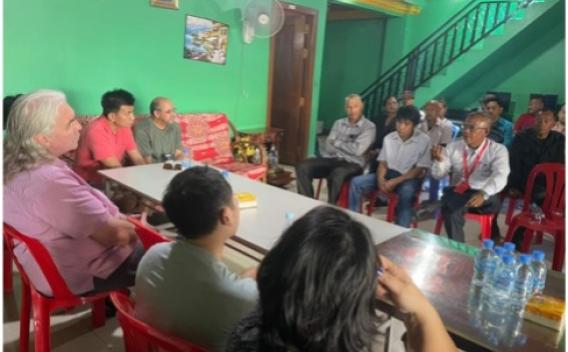 Group of Cambodian deportees sit around a table 