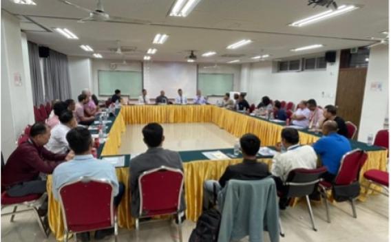 Large classroom with a crowd gathered around a conference table