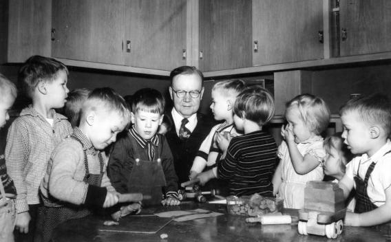 John Anderson surrounded by a group of children at the nursery school