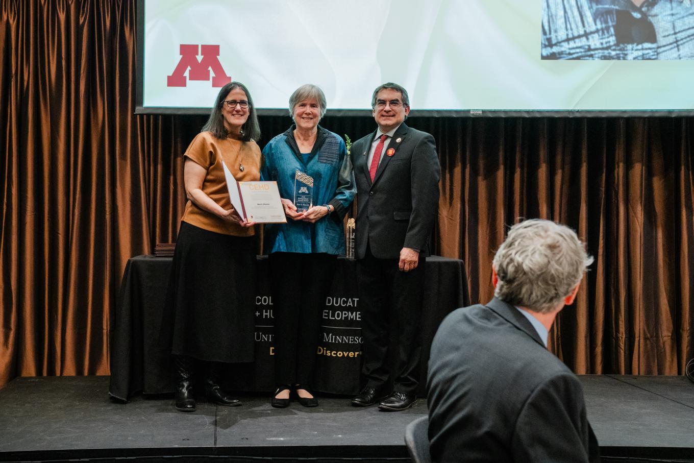 ICD Director Kathleen Thomas and CEHD Dean Michael Rodriguez stand alongside Professor Emerita Ann Masten, recipient of a 2025 Distinguished Alumni Award