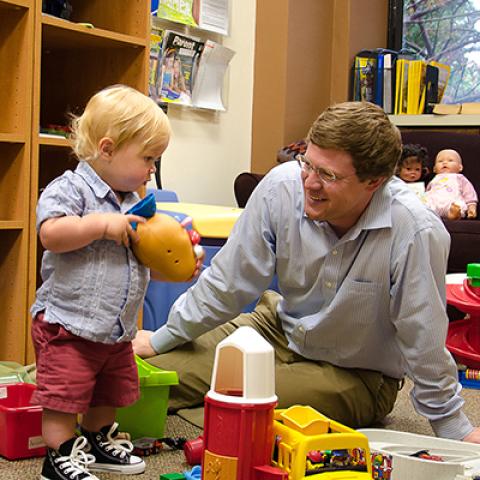 Adult and child playing with toys